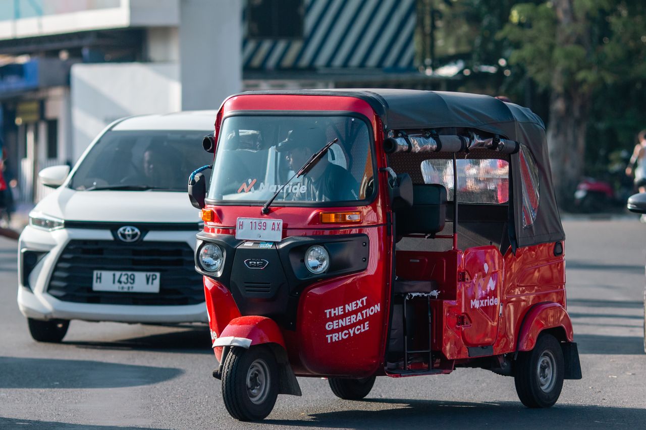 The Art of Drawing Readers In: Your attractive post title goes here Red auto rickshaw navigating city traffic, showcasing urban transportation.